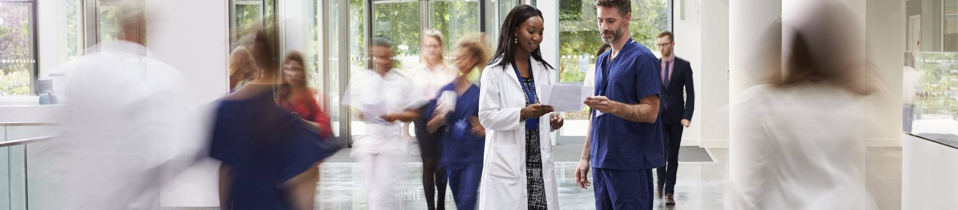 Staff In Busy Lobby Area Of Modern Hospital